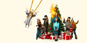 A chaotic group of kids with a woman around a burning Christmas tree. One girl is swinging on golden tinsel as an angel